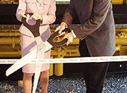 Man and a woman preforming a ribbon cutting